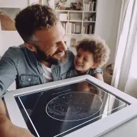 Father and son holding a Starrymaps star map print